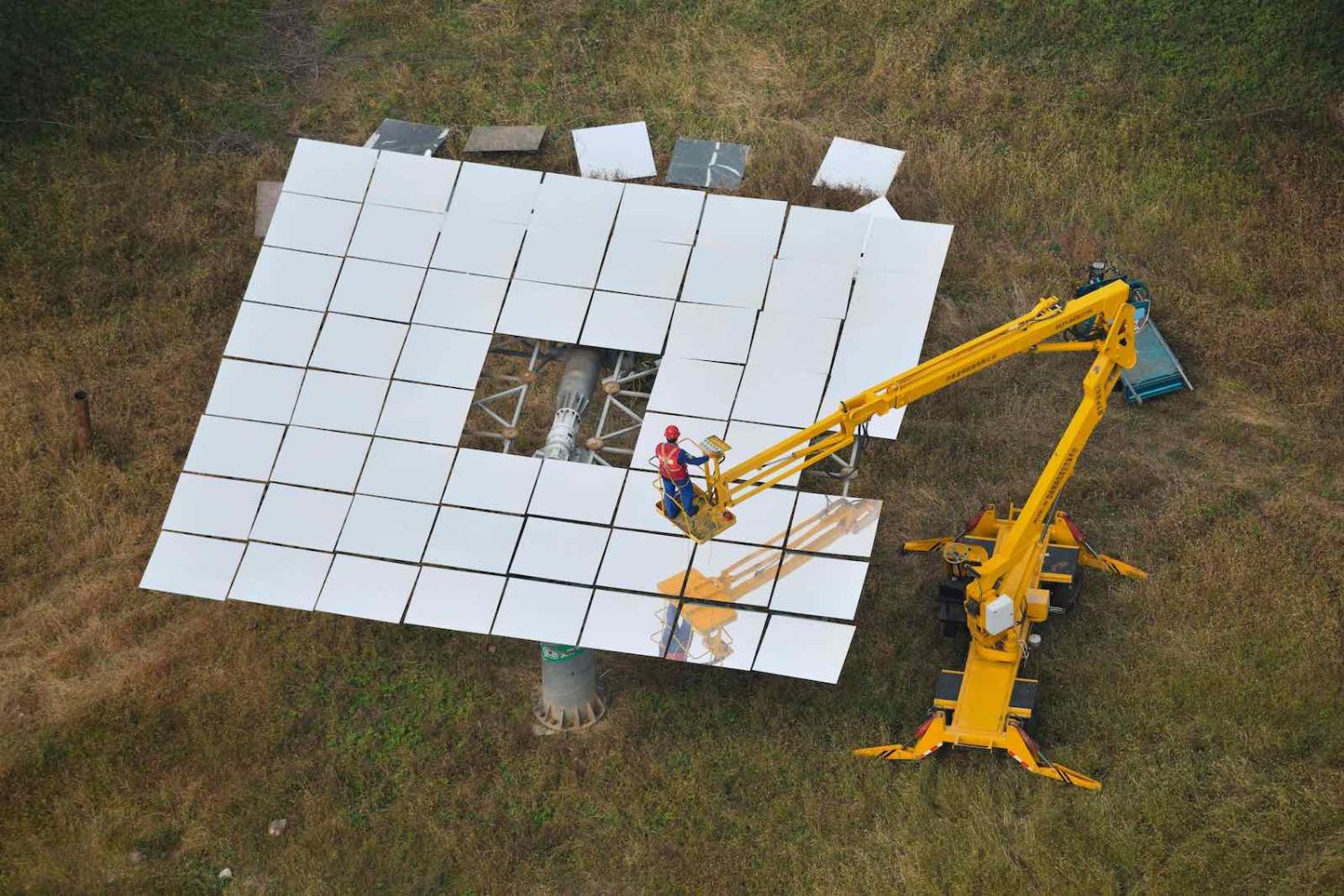 A worker replacing mirrors on a heliostat at the Yanqing Solar Thermal Power Generation Base, in Yanqing, China, north of Beijing, 28 September 2020 (Greg Baker/AFP via Getty Images)